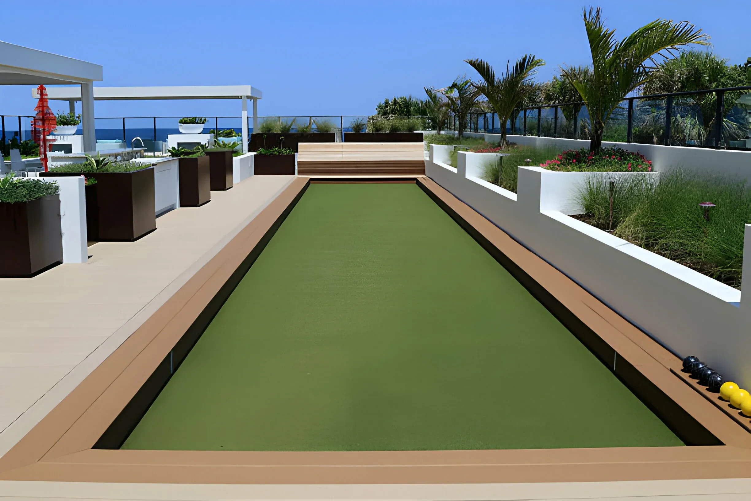 Synthetic bowling green installed on a Perth rooftop terrace with white walls and planter beds