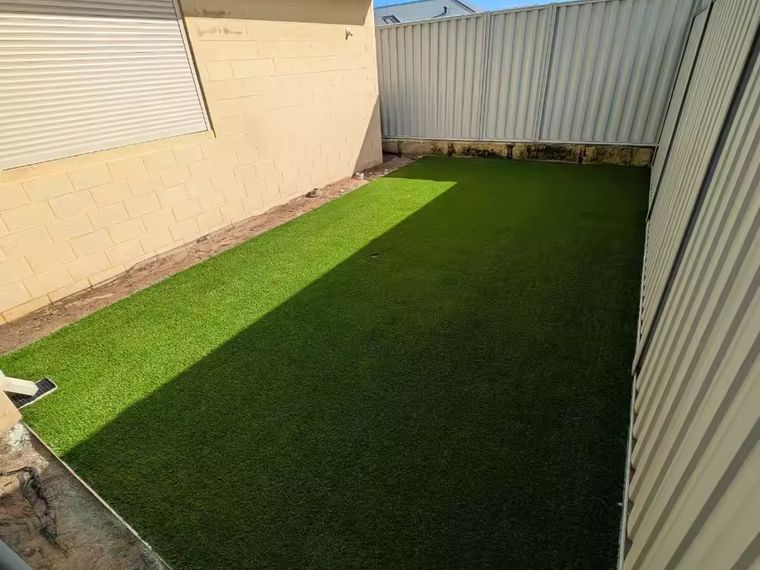Artificial grass lawn laid along a fence line in a Perth back yard