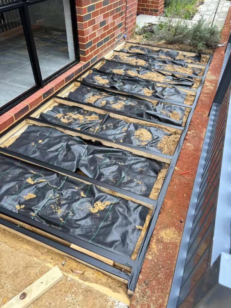 Composite decking subframe with weed matting laid between the joists, Perth