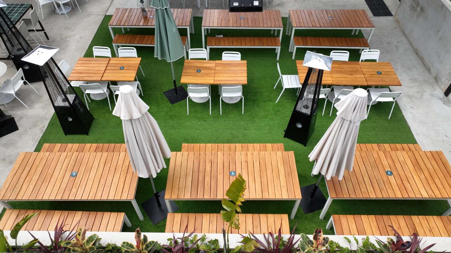 Aerial view of a Perth cafe courtyard laid with Jay's synthetic grass and timber tables