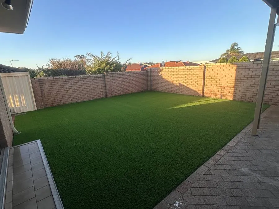 The same rear yard after artificial grass installation